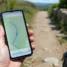 Peregrino usando aplicativo do Caminho de Santiago no celular durante a trilha