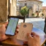 Mãos com celular e credencial do peregrino em mesa de café, planejando o Caminho de Santiago por conta própria