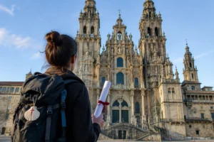 Peregrino com o tubo da Compostela diante da Catedral, na Praça do Obradoiro