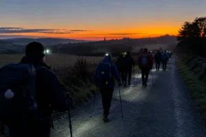Peregrinos começando a caminhar ao amanhecer: horário de saída no Caminho de Santiago