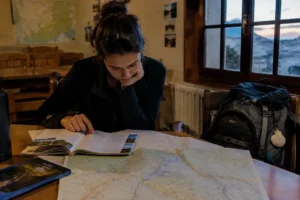 Peregrino estudando guia e mapa para mudar o roteiro do Caminho de Santiago