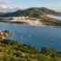 Vista do alto de uma lagoa com barcos, dunas e praia oceânica, em paisagem de ilha no sul do Brasil