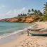 Praia tranquila de vilarejo com falésias avermelhadas, coqueiros e barco de pesca na areia