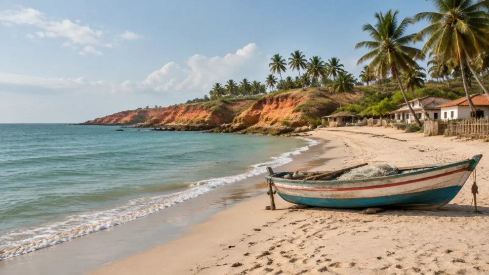 Praia tranquila de vilarejo com falésias avermelhadas, coqueiros e barco de pesca na areia