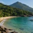 Enseada de areia dourada com Mata Atlântica descendo até o mar e barcos ancorados