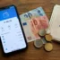 Carteira digital no celular ao lado de euros: Wise, Nomad ou dinheiro no Caminho de Santiago